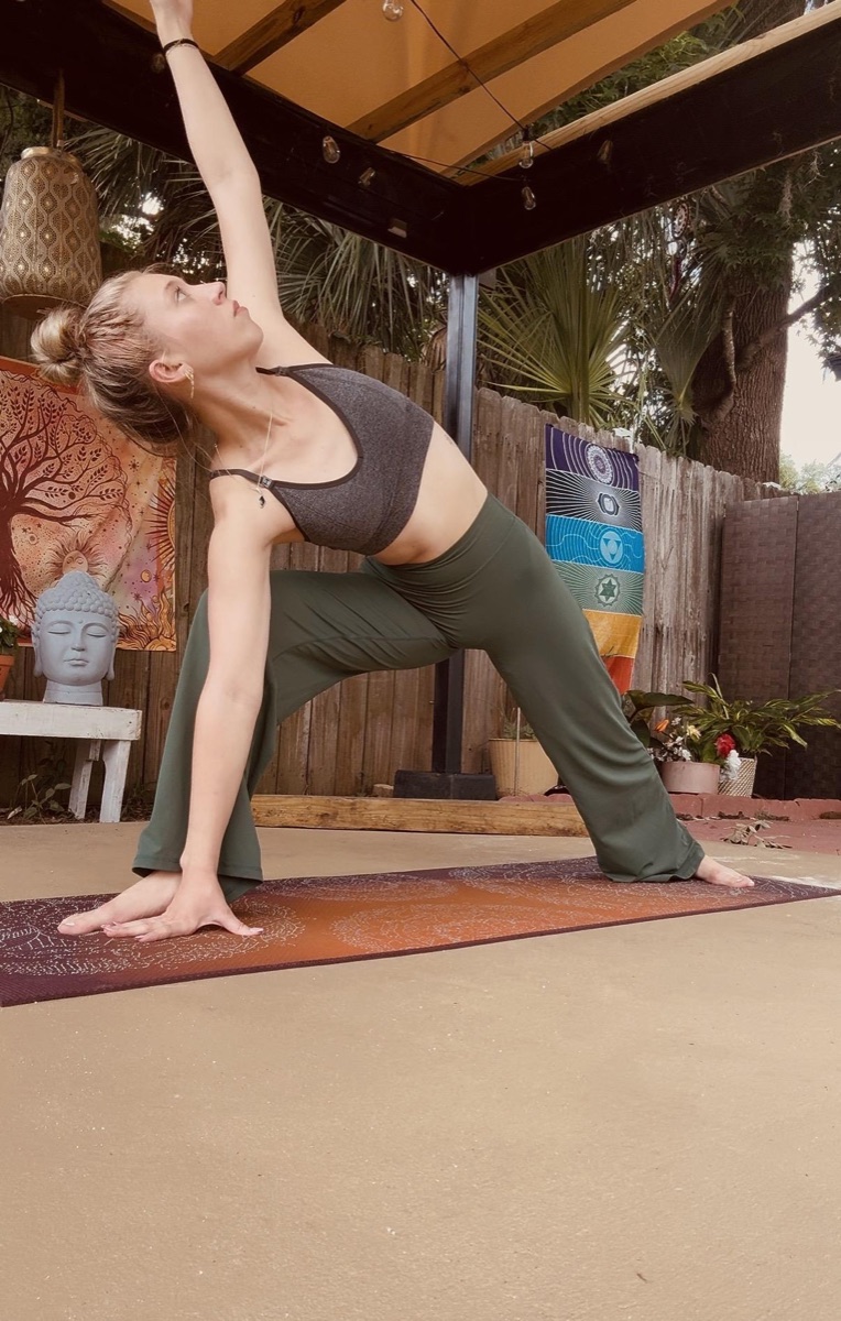 Kadence in an extended side-angle pose in a garden studio